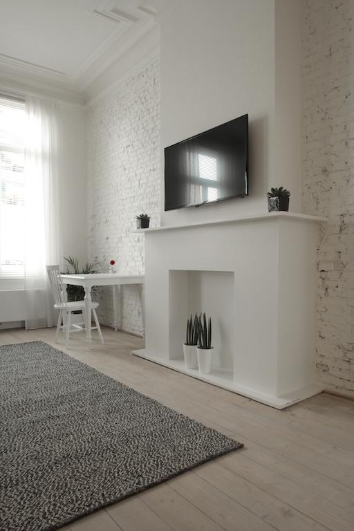 Maison Nationale City Flats & Suites Antwerpen Ruang foto A fireplace with a TV above it