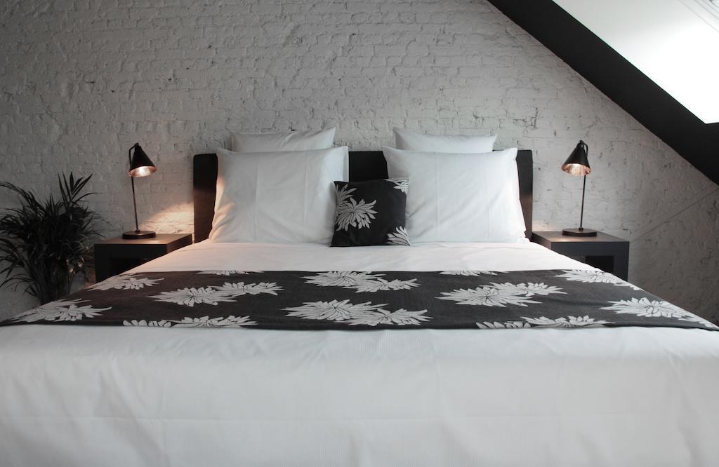 Maison Nationale City Flats & Suites Antwerpen Ruang foto A bed with a bed runner